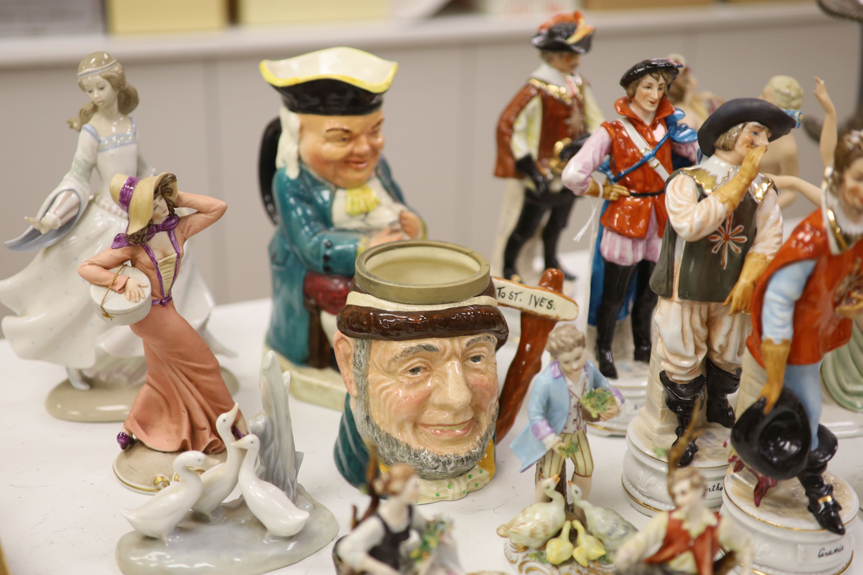 A group of porcelain figurines and two Toby jugs